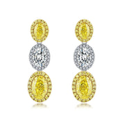 4.4 Carat Oval Cut Halo Three Stone Fancy Yellow Lab Grown Diamond Drop Earrings.