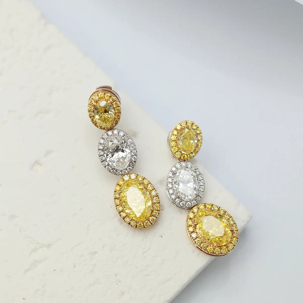 4.4 Carat Oval Cut Halo Three Stone Fancy Yellow Lab Grown Diamond Drop Earrings.