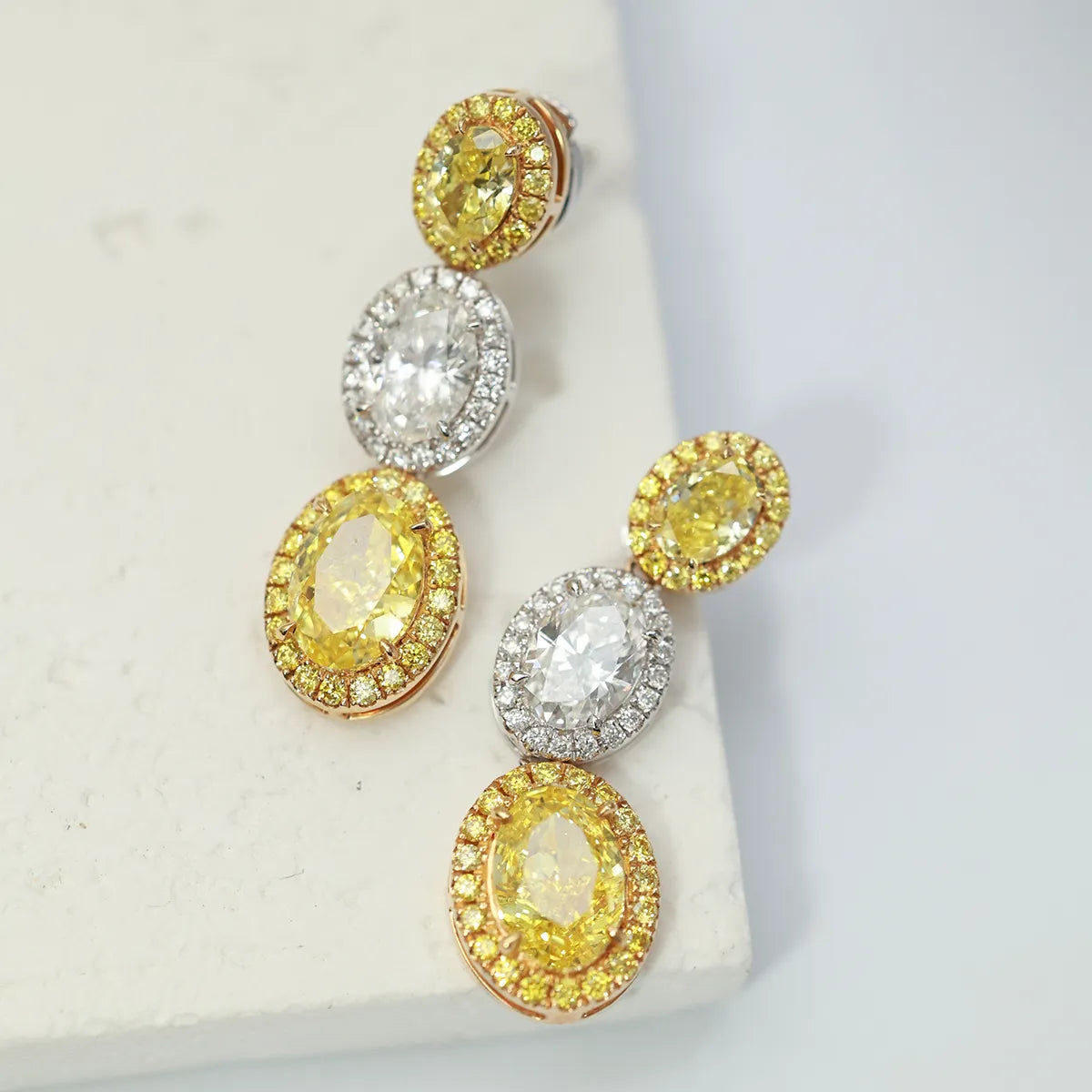 4.4 Carat Oval Cut Halo Three Stone Fancy Yellow Lab Grown Diamond Drop Earrings.