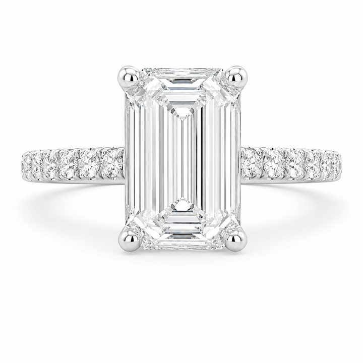 An emerald-cut diamond ring with a silver-toned pavé band, shown on a clean white background.