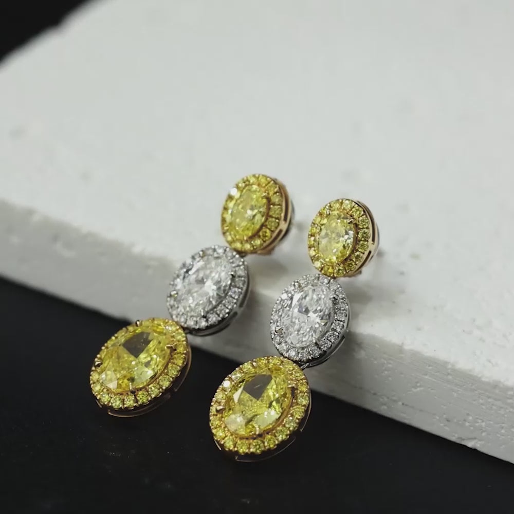 4.4 Carat Oval Cut Halo Three Stone Fancy Yellow Lab Grown Diamond Drop Earrings.
